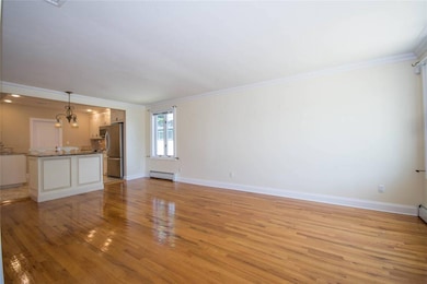 Unfurnished living room featuring a baseboard heating unit, crown molding, light wood-type flooring, and a chandelier