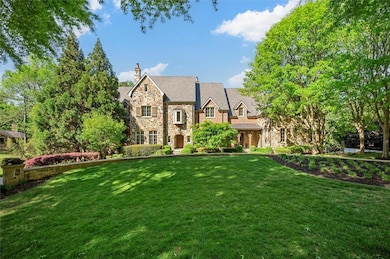Tudor house featuring stone siding, a chimney, and