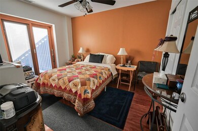 Bedroom with dark hardwood / wood-style flooring a