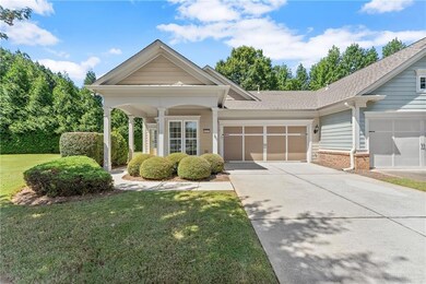 View of front facade with a front yard, driveway, a garage, a shingled roof, and brick siding