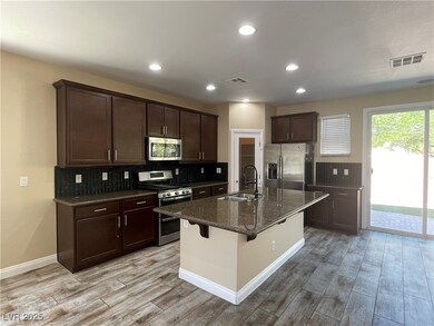 Kitchen with stainless steel appliances, light woo