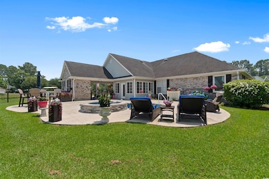 Back of property with a patio area, outdoor lounge area, brick siding, and a shingled roof