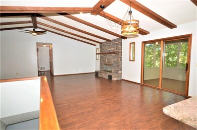 Another view from the kitchen. Notice the native rook surround for the gas log fireplace. The sliding glass doors provide access to the large screened in porch.