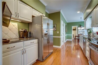 Galley Kitchen with hardwoods, SS appliances, granite counters, moldings and Kraftmaid cabinets.