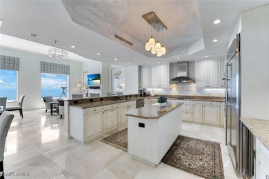 Kitchen with wall chimney range hood, a chandelier