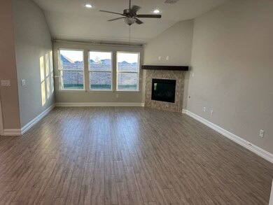 Unfurnished living room with lofted ceiling, a ceiling fan, wood finished floors, a tiled fireplace, and recessed lighting