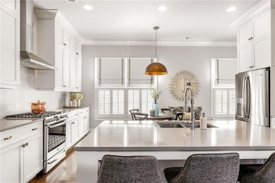 Kitchen with white cabinets, wall chimney range ho