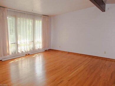 The living room has wood flooring and a vaulted ce