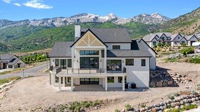 Rear view of house featuring a balcony, stucco siding, a chimney, and a mountain view