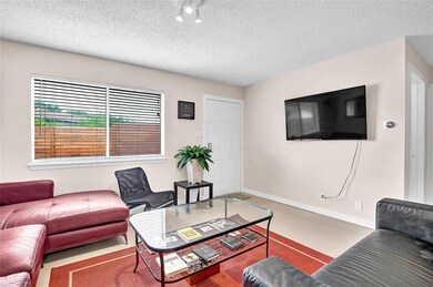 Living area featuring baseboards and a textured c