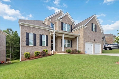 View of front of property featuring driveway, brick siding, a garage, and a front lawn