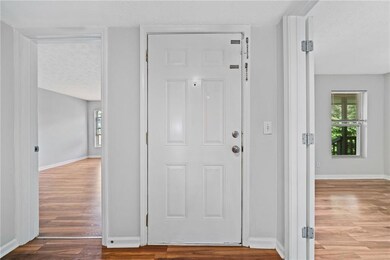 Entrance foyer featuring wood finished floors, a textured ceiling, and baseboards