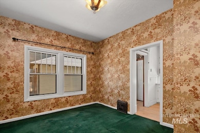 Carpeted spare room with baseboards