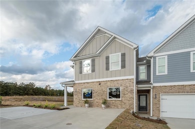 Craftsman house featuring board and batten siding, brick siding, and concrete driveway