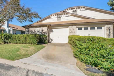 View of front of property with driveway, a shingled roof, brick siding, and a front yard