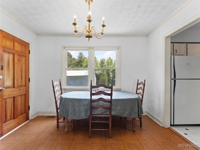 Dining space featuring a chandelier and crown mold