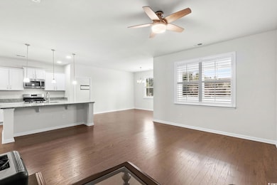 Unfurnished living room featuring dark wood finished floors, a chandelier, ceiling fan, and recessed lighting
