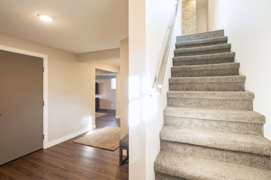 Stairs with wood finished floors and baseboards
