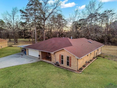 View of front of house featuring a garage and a ya