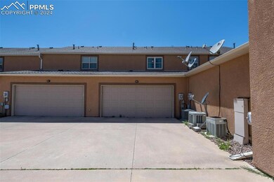 View of front facade featuring a garage and central AC unit