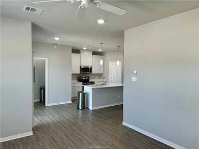 Kitchen with ceiling fan, visible vents, appliance