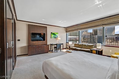 Bedroom with ornamental molding and light carpet