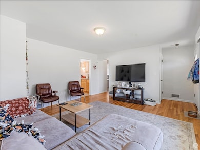 Living area with light wood finished floors and baseboards