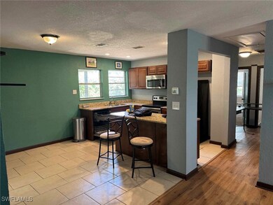 Kitchen featuring baseboards, appliances with stai