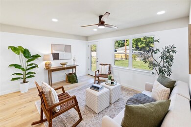 Living room with ceiling fan and light hardwood / 