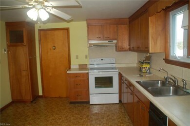 Kitchen featuring sink, ceiling fan, white electric range oven, dark tile floors, and black dishwasher