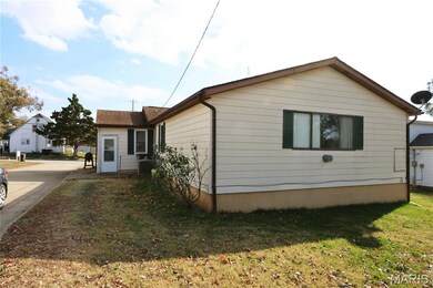 View of side of property featuring a lawn and a central AC unit