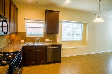Kitchen, opens to breakfast area, then to family room beyond.