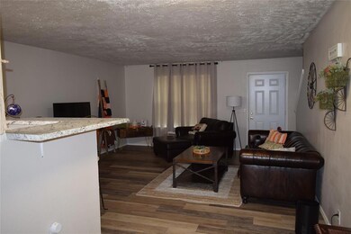 Living area featuring wood finished floors and a textured ceiling