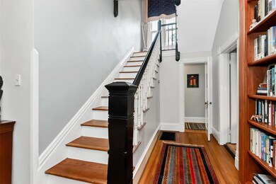 The second staircase is at the back of the living room. Door to the library/music room is on the right and the back hall is straight ahead.