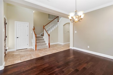 Foyer entrance with wood-type flooring, arched wa