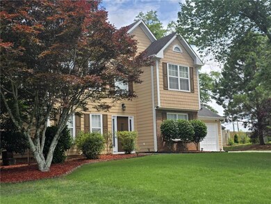View of front of property featuring a front lawn and a garage