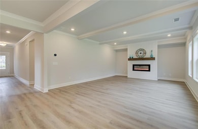 Unfurnished living room with light wood-style flooring, crown molding, a large fireplace, baseboards, and recessed lighting