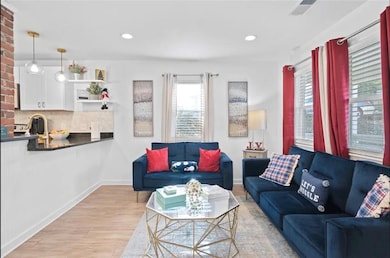 Living area with healthy amount of natural light, light wood-style flooring, baseboards, and recessed lighting