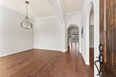 Formal dining room with hardwood floors and plantation shutters.