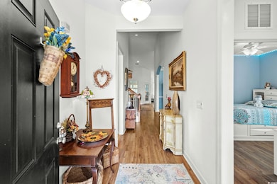 Hall with light wood-type flooring and arched walkways