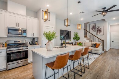 The chef kitchen features a quartz island for seating and stainless steel appliances.