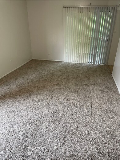 Carpeted spare room featuring baseboards