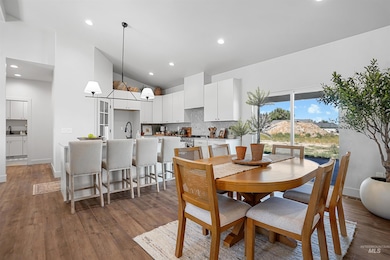 Dining space featuring high vaulted ceiling, wood finished floors, and recessed lighting