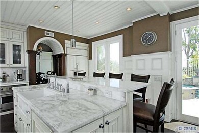 Carrara marble tops the enlarged kitchen island, b