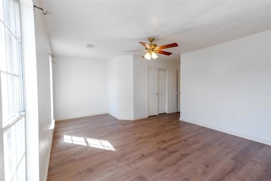 Empty room featuring wood finished floors and a ceiling fan