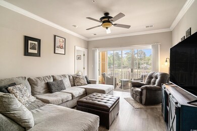 Living area featuring a ceiling fan, light wood-type flooring, and ornamental molding