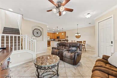 Living room with stairs, light tile patterned floo
