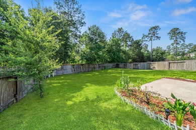 Spacious fenced backyard with lush green lawn and