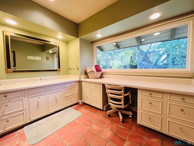 Windows accent this large bathroom looking into courtyard. Contain walk in closet.