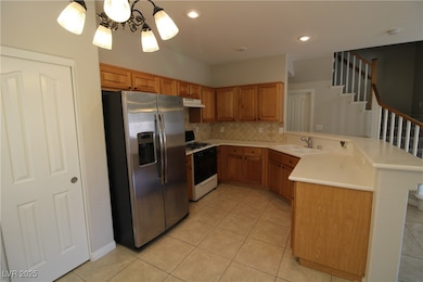 Kitchen with a peninsula, stainless steel fridge w